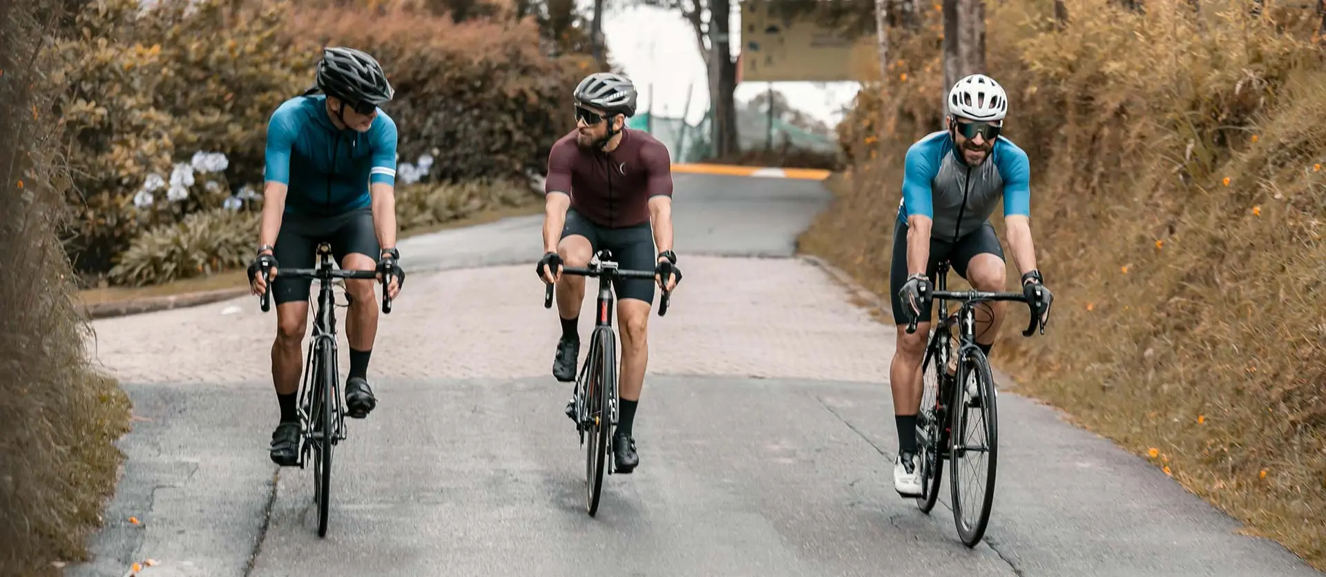 Three road cyclist riding together in a line on a wide bike path.