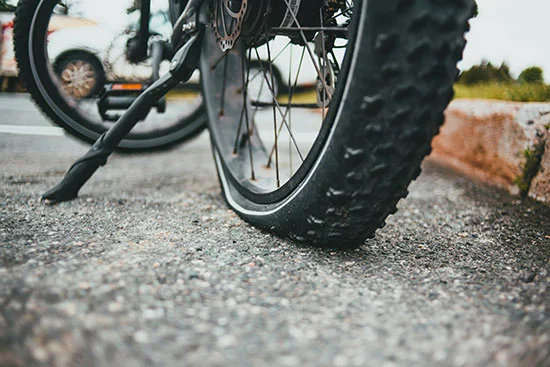 an upclose picture of a flat bicycle tire colpasing underneath the bikes weight.