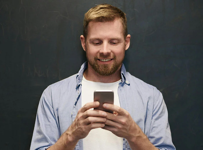 A man looking down at his cell phone.