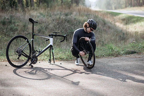 A man removing and fixing a flat tire on a road bike.